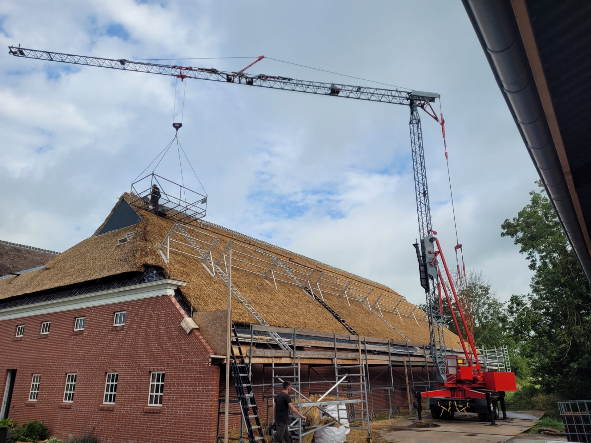 Rietdak in aanbouw met kraan en steigers